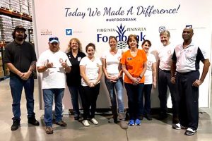 Volunteers pause for a photo after stuffing boxes and backpacks of food.