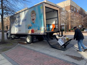 Virginia Peninsula Foodbank staff member loads the truck with a box of collected donations.